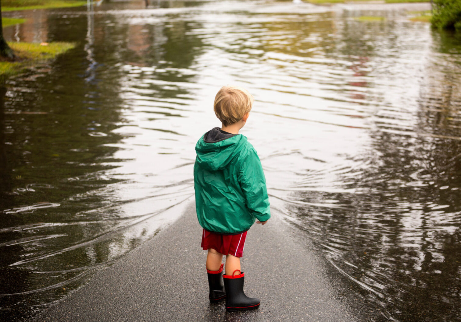 Caucasian boy wearing puddles near flood